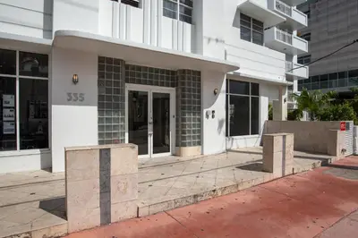 a white building with a door in front of it at So South Beach in Miami Beach