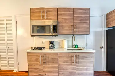 a kitchen with wooden cabinets and a microwave at So South Beach in Miami Beach