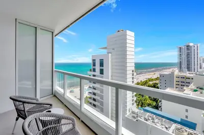 a balcony with chairs and a view of the ocean at Luxury Oceanview Suite at the Fontainebleau Miami Beach with Balcony, King & Sofa Bed in Miami Beach