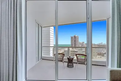 a balcony with glass doors and a table and chairs at Luxury Oceanview Suite at the Fontainebleau Miami Beach with Balcony, King & Sofa Bed in Miami Beach