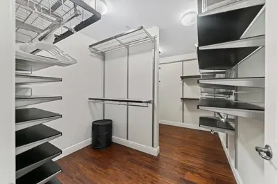 a kitchen with stainless steel shelves and a hardwood floor at Lux Home with Rooftop & Elevator 2mi to Beach in Fort Lauderdale