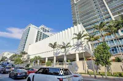 a white car parked in front of a large building at Spectacular 1-Bedroom Sea View Luxury & Comfort in Miami Beach