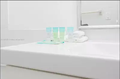 a bathroom counter with a mirror and a sink at UNIT #908 Castle Beach Club Condominium in Miami Beach
