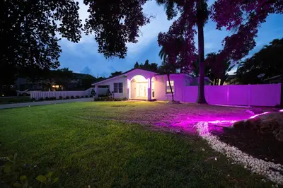 a house with purple lights in a yard at night at Hollywood Beach home in Hollywood