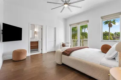 a white bedroom with a bed and a flat screen tv at Riviera Reserve by Stay Awhile Villas in Fort Lauderdale