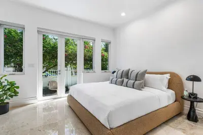a white bedroom with a large bed and windows at Riviera Reserve by Stay Awhile Villas in Fort Lauderdale