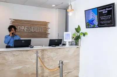a woman talking on a cell phone at a reception desk at President Hotel Villa in Miami Beach