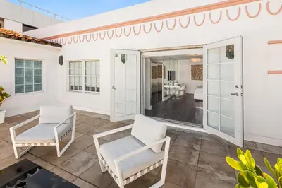 a patio with two white chairs and a table at President Hotel Villa in Miami Beach