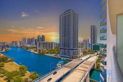 a view of a city with a river and a bridge at Stylish 2BR High-Rise Retreat w Ocean Views in Hallandale Beach