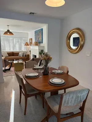 a living room with a wooden table and chairs at Mid-Century with Outdoor Oasis in Fort Lauderdale