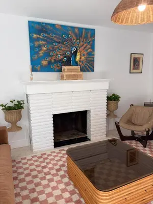 a living room with a fireplace with a painting at Mid-Century with Outdoor Oasis in Fort Lauderdale