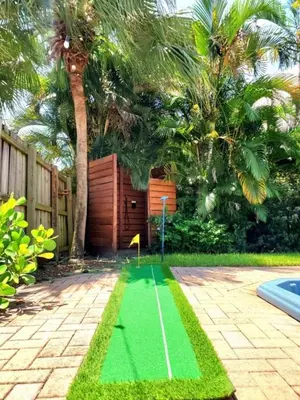 a green obstacle course in a backyard with palm trees at Fox Island Heated Spa- Downtown & Beach home in Fort Lauderdale