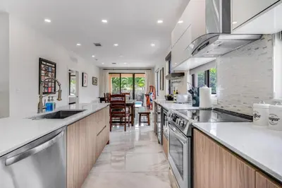 a kitchen with white counter tops and wooden cabinets at Fox Sonata Downtown Pool House home in Fort Lauderdale