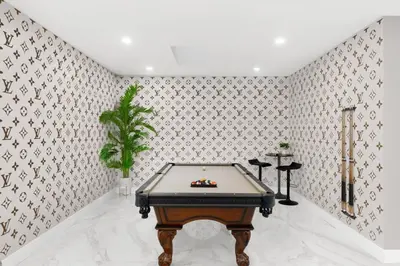 a pool table in a room with wallpaper at Golden Fox Downtown Pool House home in Fort Lauderdale