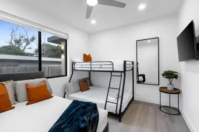a bedroom with a bunk bed and a couch at Golden Fox Downtown Pool House home in Fort Lauderdale