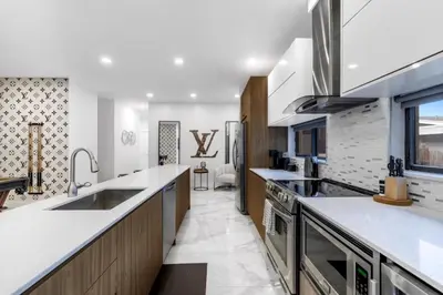 a kitchen with white countertops and a large sink at Golden Fox Downtown Pool House home in Fort Lauderdale