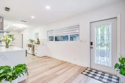 an empty living room with white walls and a large door at Fox Private Resort- Near Downtown & Beach home in Fort Lauderdale
