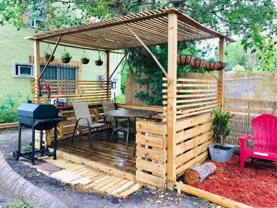 a wooden pergola with a table and a grill at Designer 2br, king-size bed, 5mins to the beach J1 in Hollywood