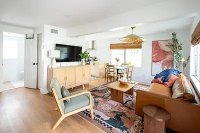 a living room with a couch and a table at Designer Gem Condo - 5 Mins to Sand, Playground, Tennis, Free Parking in Hollywood