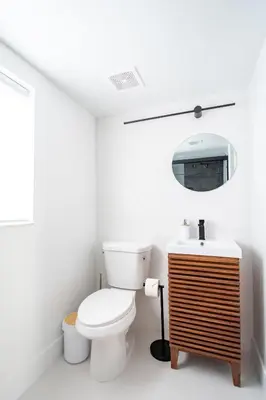 a white bathroom with a toilet and a sink at Designer Gem Condo - 5 Mins to Sand, Playground, Tennis, Free Parking in Hollywood