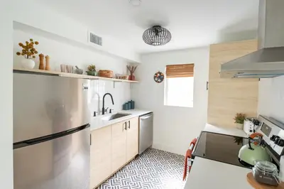a kitchen with a refrigerator and a sink at Designer Gem Condo - 5 Mins to Sand, Playground, Tennis, Free Parking in Hollywood