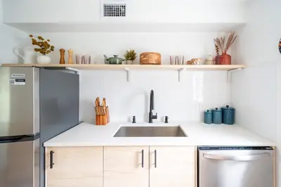 a kitchen with a sink and a refrigerator at Designer Gem Condo - 5 Mins to Sand, Playground, Tennis, Free Parking in Hollywood