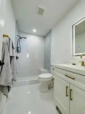 a white bathroom with a toilet and a sink at Modern Hollywood Beach Retreat 2BDx2BTH - Games, WiFi, AC in Hollywood