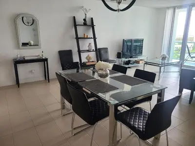 a dining room with a glass table and chairs at Lovely condo on the Beach - Tides Hollywood 14th Floor in Hollywood