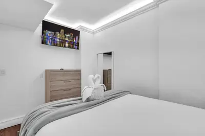 a white bedroom with a white bed and a painting on the wall at Resort at Sunny Isles Beach with Ocean view in Sunny Isles Beach