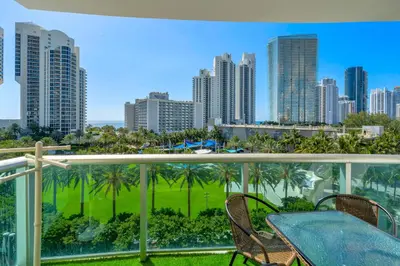 a balcony with a table and chairs and a city at Resort at Sunny Isles Beach with Ocean view in Sunny Isles Beach