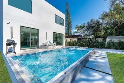 a swimming pool in front of a house at Luxe Pool House in North Miami Perfect for Groups in North Miami Beach