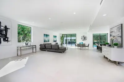 a white living room with white floors and windows at Luxe Pool House in North Miami Perfect for Groups in North Miami Beach