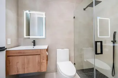 a bathroom with a toilet and a sink and a shower at Luxe Pool House in North Miami Perfect for Groups in North Miami Beach