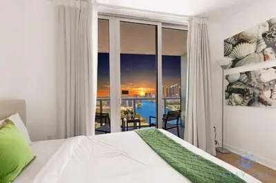 a bedroom with a bed and a view of the city at Coastal Retreat Modern Studio w Harbour Views in Hallandale Beach