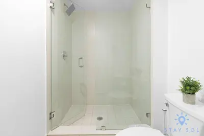 a white bathroom with a shower and a sink at Coastal Retreat Modern Studio w Harbour Views in Hallandale Beach