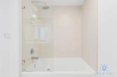 a white bathroom with a tub and a shower at Stylish 1BR High Rise Retreat w Ocean View in Hallandale Beach