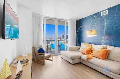 a living room with a white couch and a blue wall at Stylish 1BR High Rise Retreat w Ocean View in Hallandale Beach