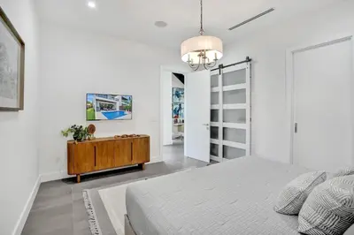 a bedroom with a bed and a dresser in it at New Luxe Contemporary Home 4BR-4BA with Heated Pool, Mini Golf, Pool table in Fort Lauderdale