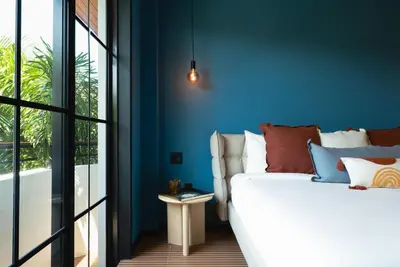 a bedroom with blue walls and a bed with a side table at Maison Felix in Miami Beach