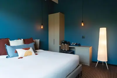 a bedroom with a white bed and a blue wall at Maison Felix in Miami Beach