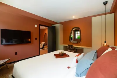 a bedroom with a white bed and a flat screen tv at Maison Felix in Miami Beach