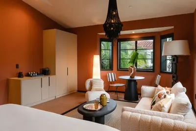 a bedroom with orange walls and a living room at Maison Felix in Miami Beach