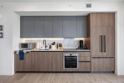 a kitchen with stainless steel appliances and wooden cabinets at Ocean Dreams Chic 2BR Getaway Minutes from Miami's Top Attractions in Miami Beach