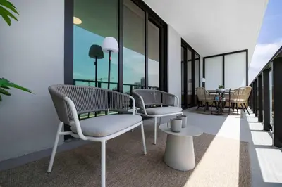a balcony with chairs and a table and windows at Miami Beach Retreat Cozy 1BR Steps from the Shore in Miami Beach