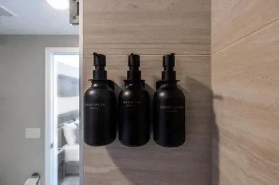 three black bottles are hanging on a wall at Chic Miami Retreat Stylish 2BR Gem for 5 in Miami Beach