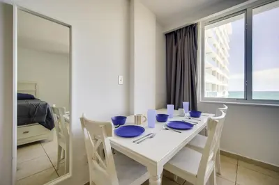 a white dining room table with blue dishes on it at Oceanfront Resort Condo with Gym and Waterfront Pool! in Sunny Isles Beach