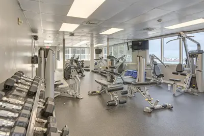 a gym with several treadmills and cardio machines at Oceanfront Resort Condo with Gym and Waterfront Pool! in Sunny Isles Beach