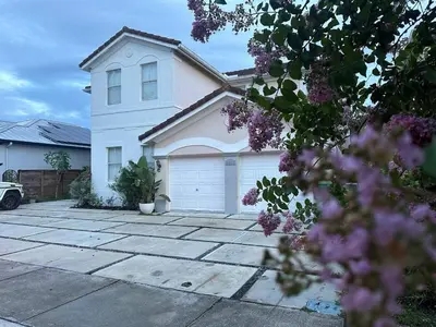 a white house with a driveway in front of it at The Garden House in Miami Lakes in Miami Lakes