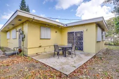 a yellow house with a table in front of it at Game Day Made Easy Home 3 Mi to Hard Rock Stadium in Miami Gardens
