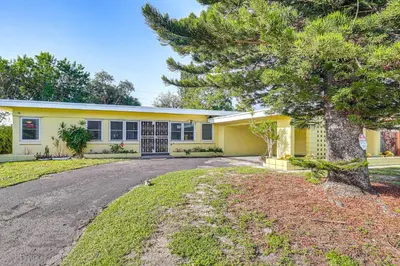a yellow house with a tree in front of it at Game Day Made Easy Home 3 Mi to Hard Rock Stadium in Miami Gardens